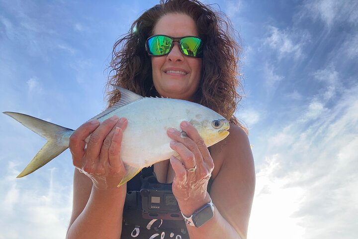 Cathy Sanders, a professional surf-fishing guide, specializes in expertly catching pompano along the coast.